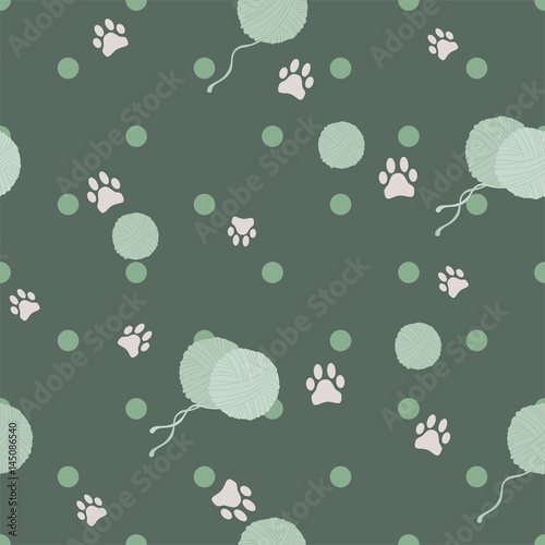 Pattern with cat paws and balls of yarn on green background. Vector illustration.