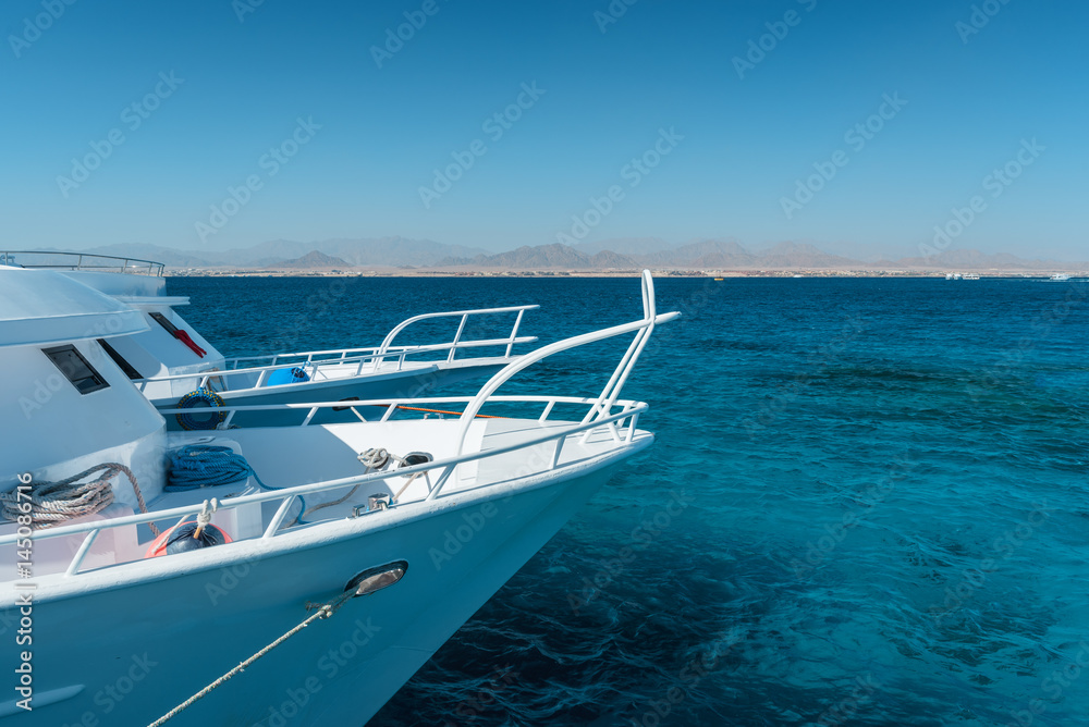 View at the coral sea and white yacht. Perfect place for snorkeling. Summer vacation at Red sea with turquoise clear water. View at the coral sea and white yacht. Perfect place for snorkeling. Summer vacation at Red sea with turquoise clear water.