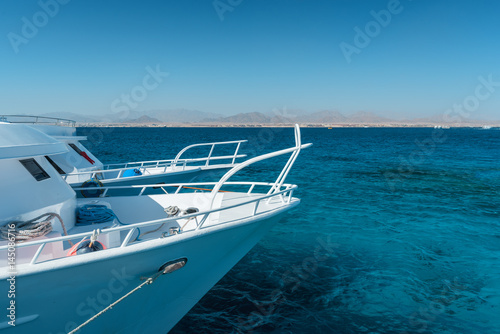 View at the coral sea and white yacht. Perfect place for snorkeling. Summer vacation at Red sea with turquoise clear water. © ianachyrva