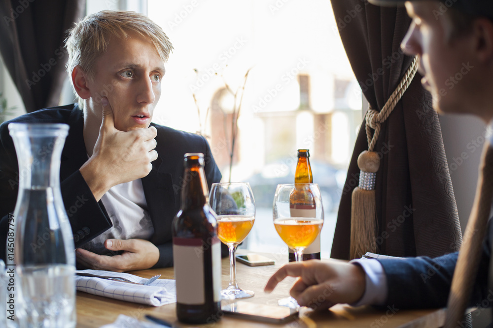 Two men talking at restaurant table Two men talking at restaurant table
