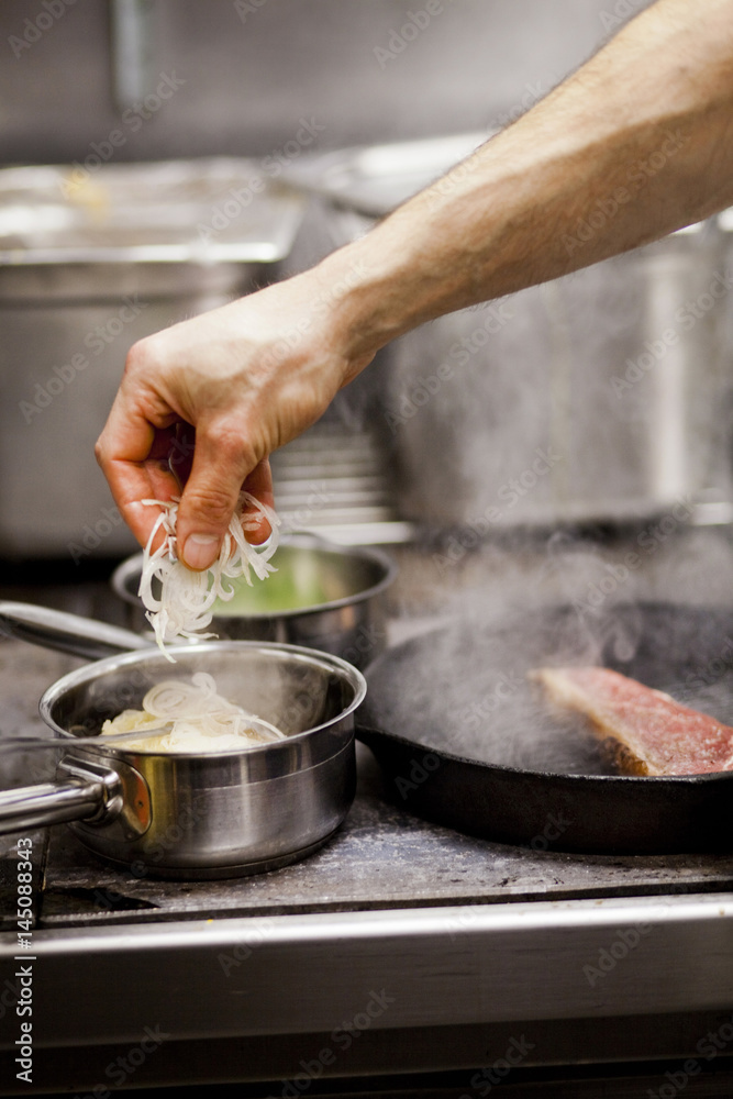 Cropped hand of chef preparing food at commercial kitchen Cropped hand of chef preparing food at commercial kitchen