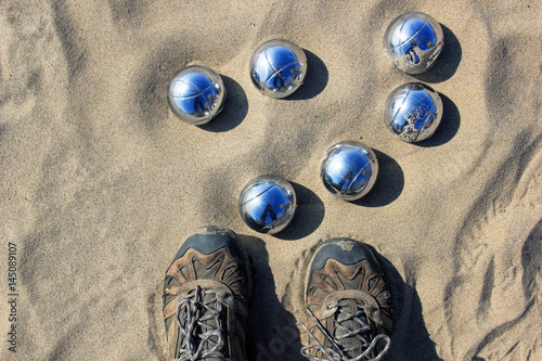 Foots in front of petanque balls. View from the top