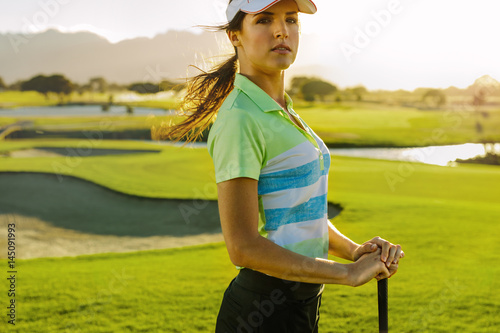 Young female golfer with golf club