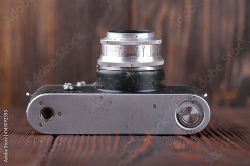The old Soviet 35 mm SLR camera on the wooden background.