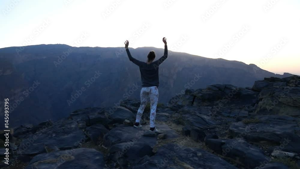 Young woman raising arms in victory in the mountains, super slow motion 240fps
Young woman raising arms in victory in the mountains, super slow motion 240fps