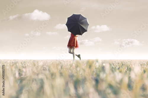 woman hides behind his black umbrella in a surreal place photo