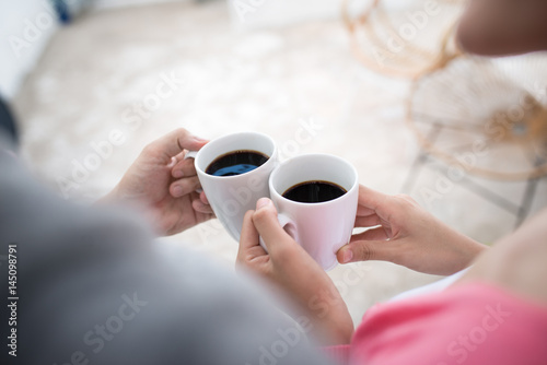 Peaceful asian young couple relaxing at home with cup of tea