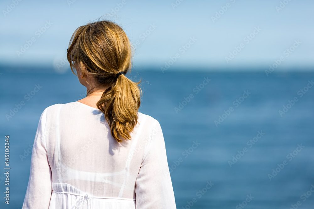 Middle-aged woman on vacation walking in marina Middle-aged woman on vacation walking in marina