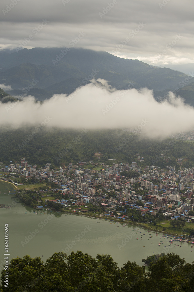 Lake Phewa and houses Pokhara, Nepal, with the Himalayan mountains in the background