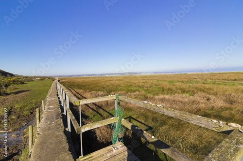 фотографія Scenic coastal view across the salt marshes & sand dunes at Red Wharf Bay from t