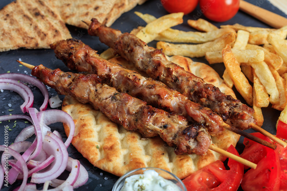 Grilled meat skewers on a pita bread - top view