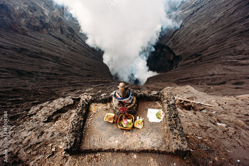 Crater of Bromo volcano and Ganesha altar with offerings in Bromo Tengger Semeru National Park, East Java, Indonesia. Erupting and active volcano