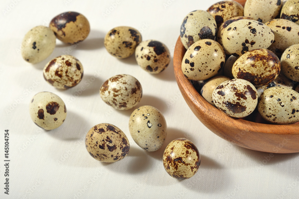 Quail eggs in a wooden bowl in a sacking Quail eggs in a wooden bowl in a sacking