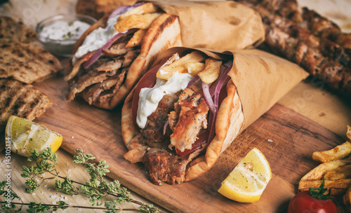 Greek gyros wrapped in pita breads on a wooden table photo