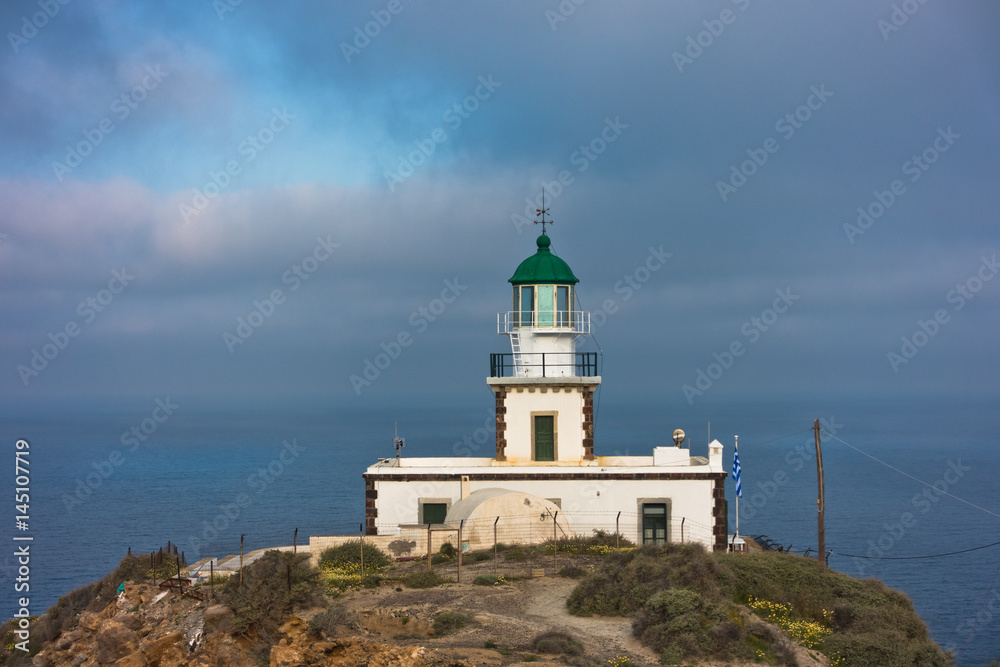 Akrotiri lighthouse at sunny morning with picturesque clouds, Santorini island, Greece