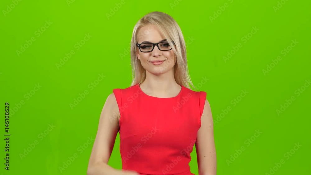 Blonde girl winks her eyes off glasses, green screen studio Blonde girl winks her eyes off glasses, green screen studio