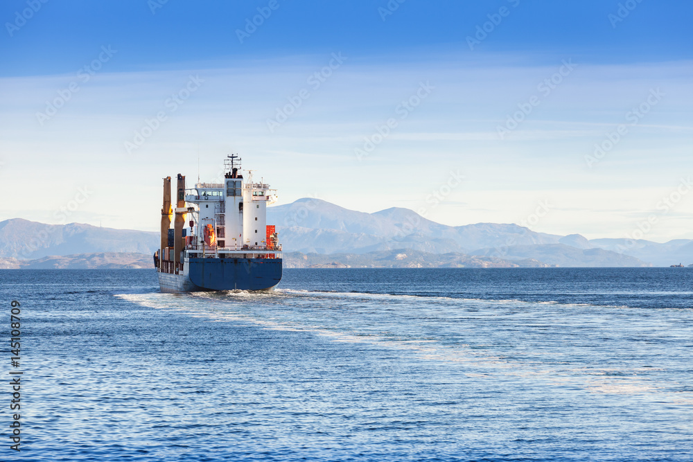 Container ship goes on Norwegian sea, rear view