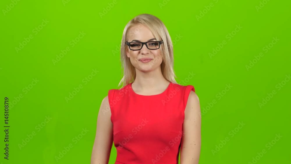 Girl puts on glasses with black rim, green screen studio Girl puts on glasses with black rim, green screen studio