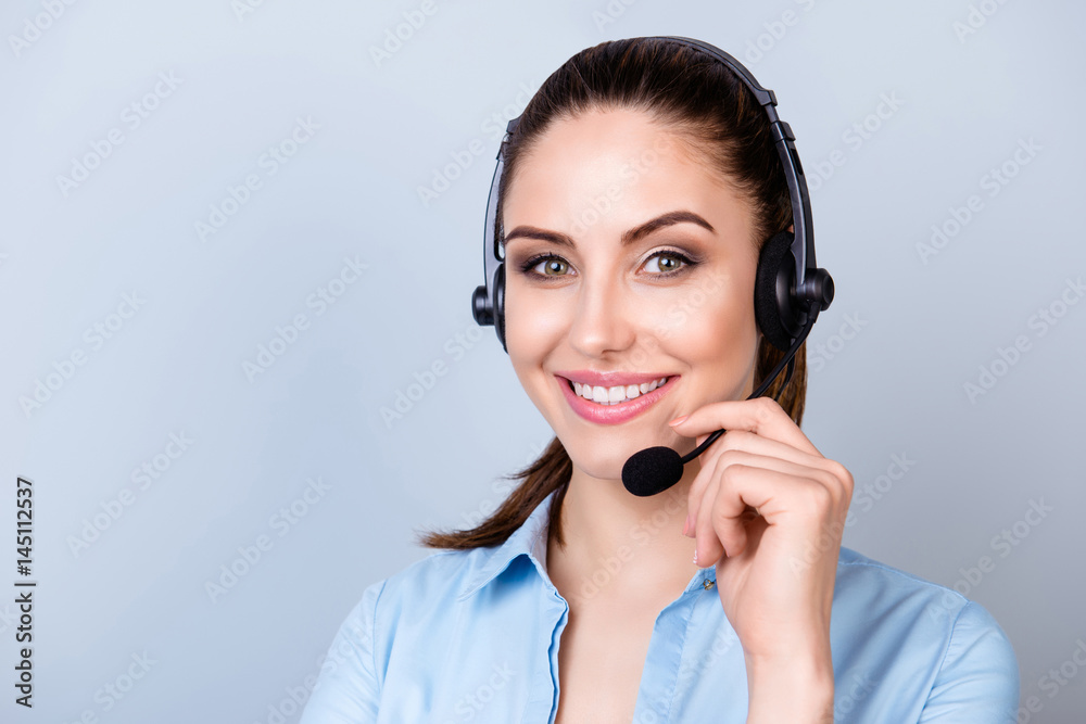 Close up portrait of smiling consultant of call center in headphones isolated on gray background Close up portrait of smiling consultant of call center in headphones isolated on gray background