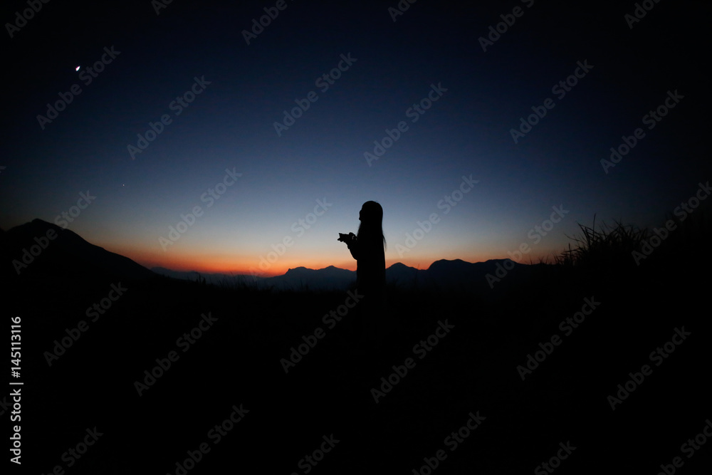 Fototapeta premium sunset silhouette, young lady in hill