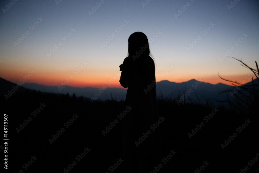 Fototapeta premium sunset silhouette, young lady in hill