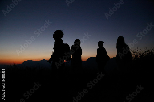 Watch the evening with a group on a hill