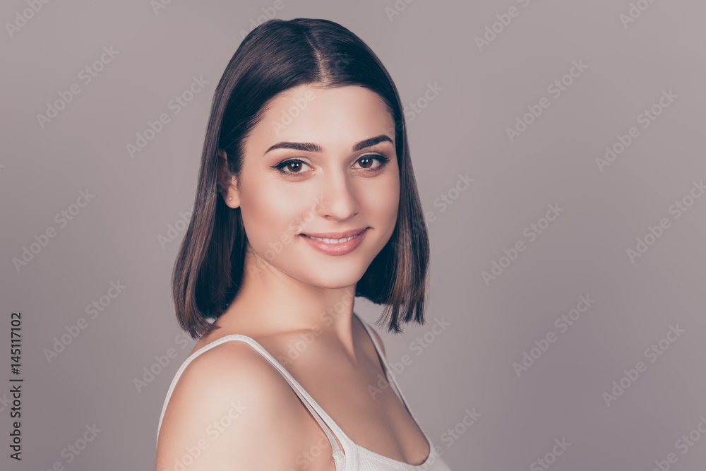 Portrait of young pretty smiling woman against grey background Portrait of young pretty smiling woman against grey background