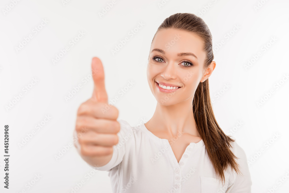 Close up portrait of smiling beautiful woman giving a thumb up as a sign of recommendation Close up portrait of smiling beautiful woman giving a thumb up as a sign of recommendation