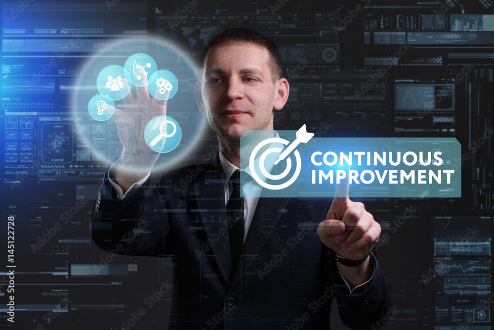 Business, Technology, Internet and network concept. Young businessman working on a virtual screen of the future and sees the inscription: Continuous improvement Business, Technology, Internet and network concept. Young businessman working on a virtual screen of the future and sees the inscription: Continuous improvement