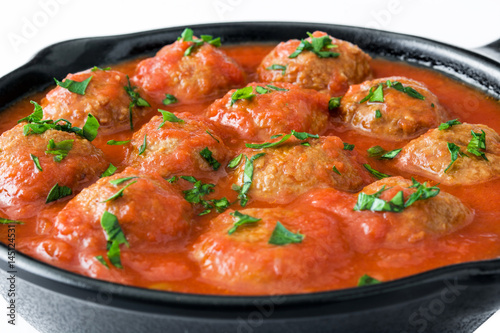 Meatballs with tomato sauce in iron frying pan isolated on white background

