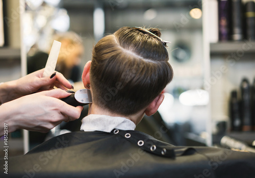 In the hairdresser's girl, make a hairstyle with a machine shaving whiskey. In the hands of a master hair clipper.