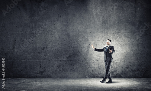 Business concept of risk with businessman wearing blindfold in empty concrete room