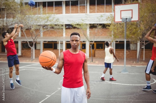 Male basketball player holding basketball in basketball court © wavebreak3