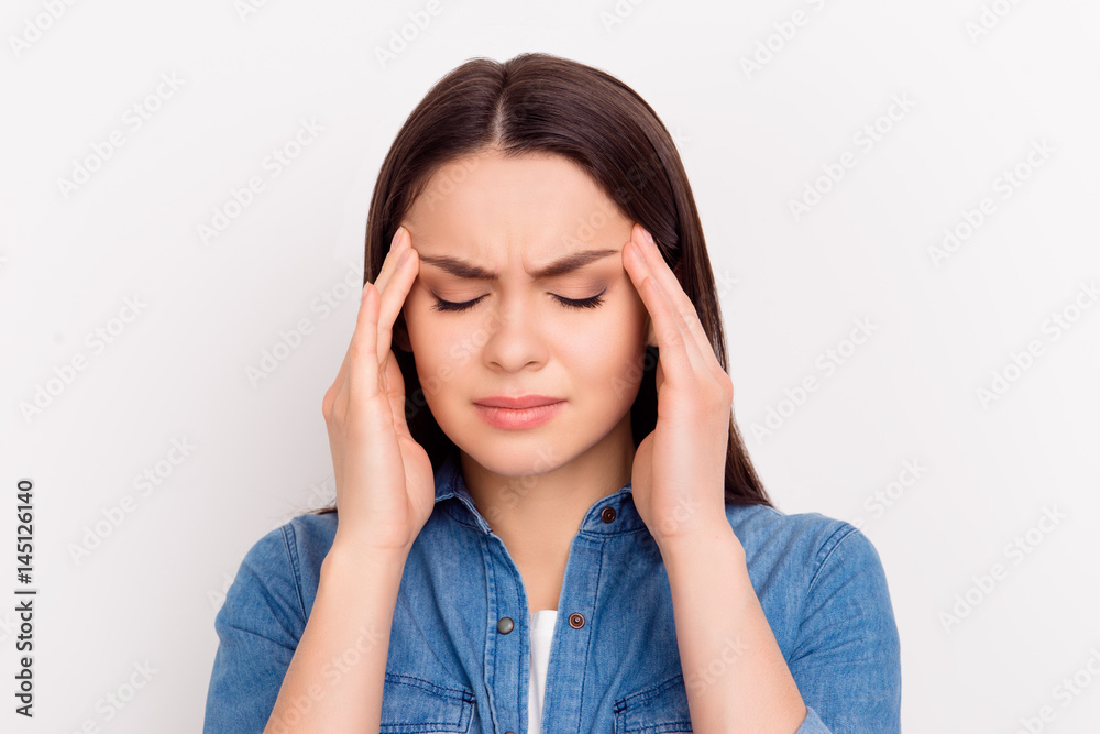 Depressed young woman with terrible headache touching head with hands Depressed young woman with terrible headache touching head with hands