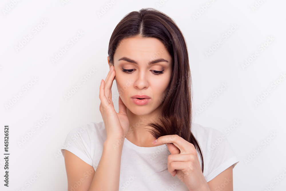 Close up portrait of young woman troubled about her hair because of splitting ends Close up portrait of young woman troubled about her hair because of splitting ends