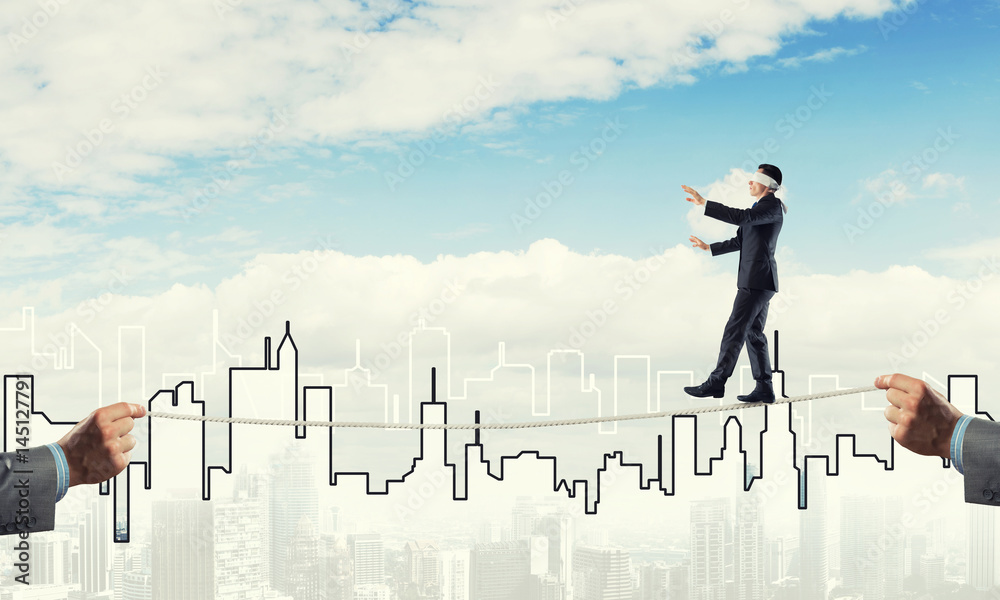 Business concept of risk support and assistance with man balancing on rope Business concept of risk support and assistance with man balancing on rope