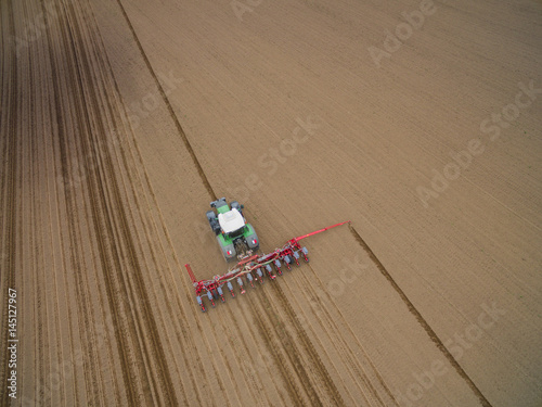 tractor - aerial view of a tractor at work cultivating a field in spring