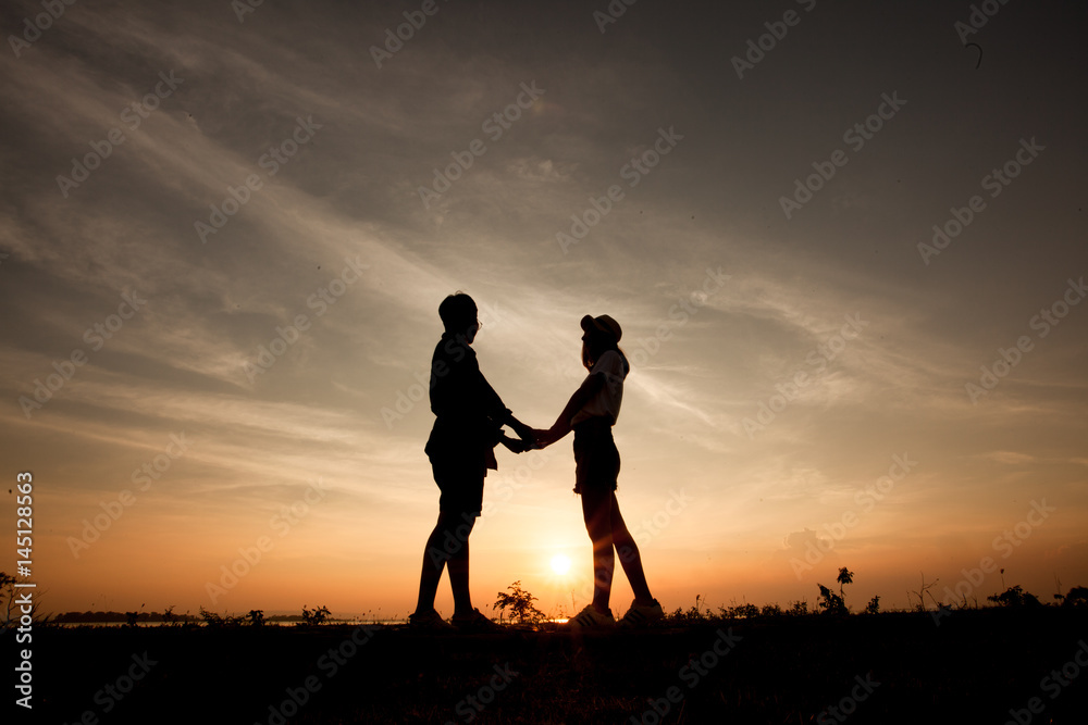 Romantic couple at colorful sunset on background