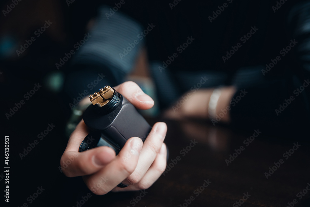 Fototapeta premium vaping man holding a mod. concept of refusal of tobacco. Vaping