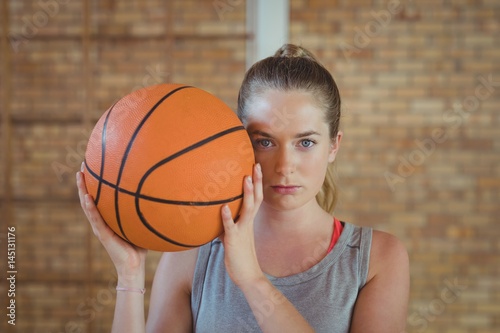 High school girl standing with basketball in the court © wavebreak3