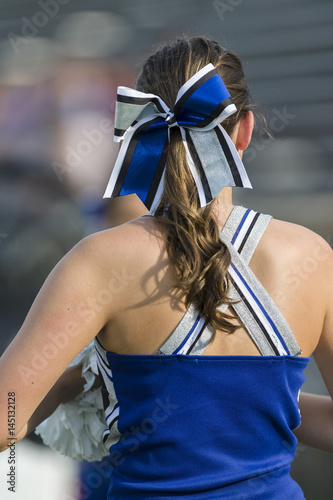 Cheerleader with festive bow from behind