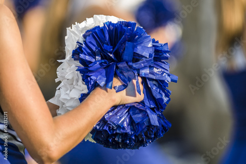 Cheerleader holding pom poms with a shallow depth of field photo
