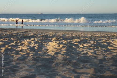 a soft sunset with people enjoying the ocean