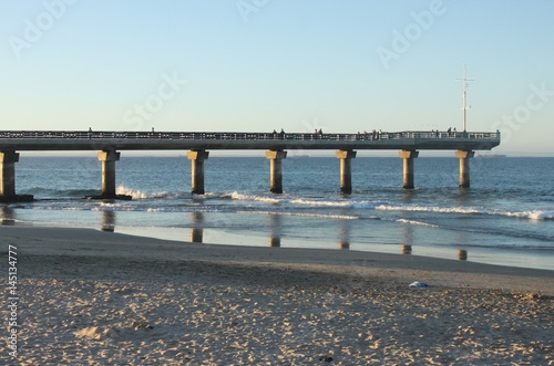 shark rock pier with waves crashing around it