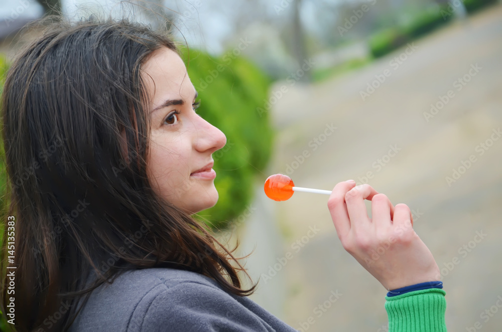 A beautiful young girl with candy on the street A beautiful young girl with candy on the street