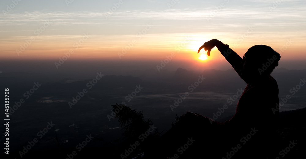 Fototapeta premium Man playing with the sun with silhouette background