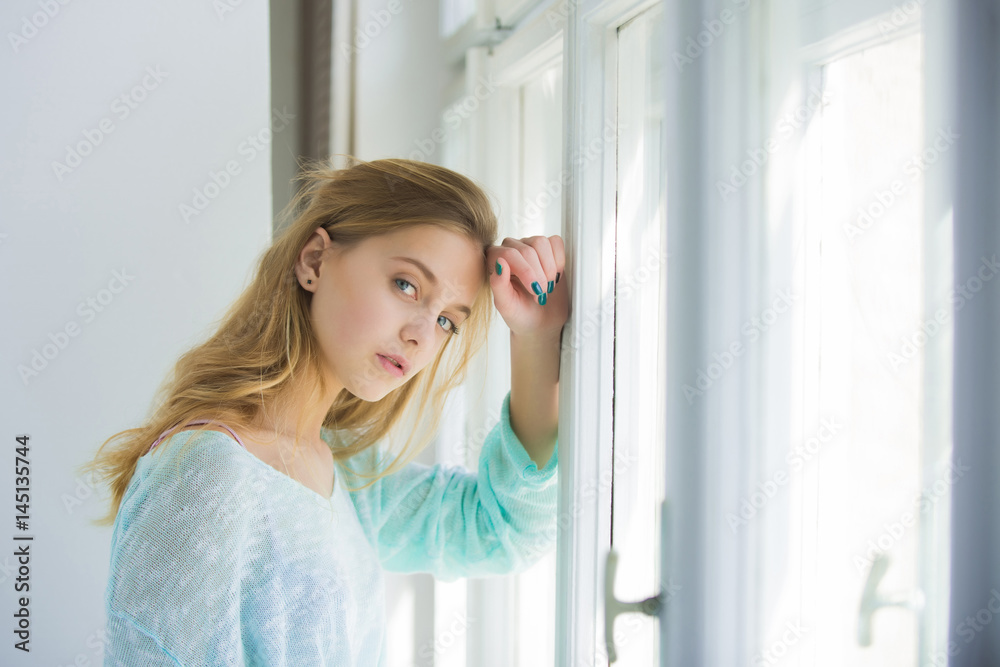 Pretty girl with blue eyes standing at window Pretty girl with blue eyes standing at window