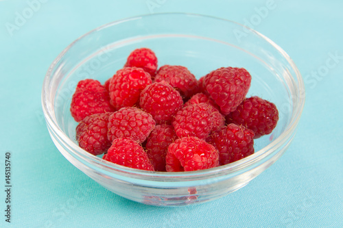 Fresh red raspberries in a glass bowl