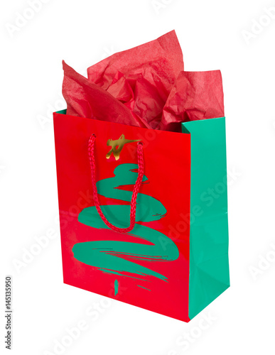 Red and green Christmas gift bag with tissue paper isolated on white photo