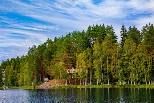 Fototapeta Naklejka Na Ścianę i Meble -  Wooden log cabin at the lake in summer in Finland